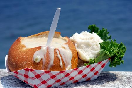 Clam chowder in a sourdough bread bowl on a wooden fishing dockの写真素材