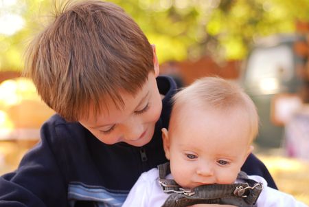 Big brother holding his baby brother at a farmの写真素材