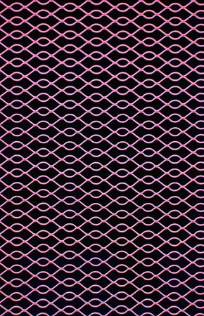 Pink metal grate over a darkened openingの写真素材