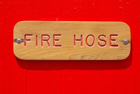 Fire Hose sign on a red painted wooden shedの写真素材