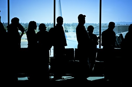 Travelers standing in line at the airport waiting to board an airplaneの写真素材