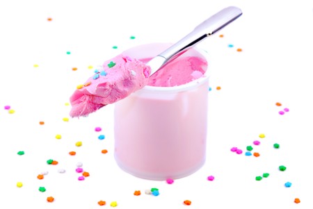 Opened tub of strawberry frosting with knife and sprinkles isolated on whiteの写真素材