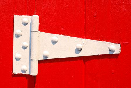 Painted white door hinge on red painted doorの写真素材