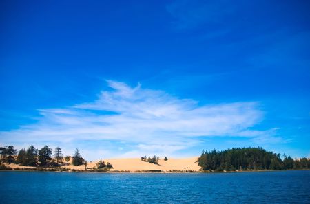 River runs past sand dunes at Oregon Dunes National Recreation Areaの写真素材