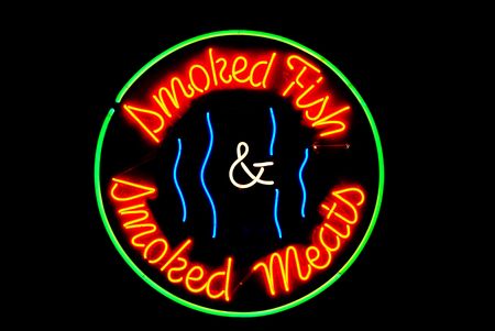 Smoked meats and fish neon sign isolated on blackの写真素材