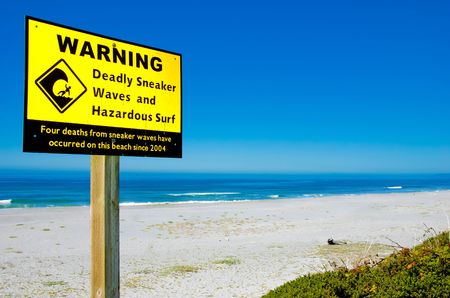 Sign warning of sneaker waves and hazardous surf on Pacific Coastの写真素材
