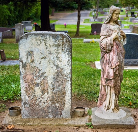 Weathered headstone with blank copyspace next to vintage statue of Jesusの写真素材