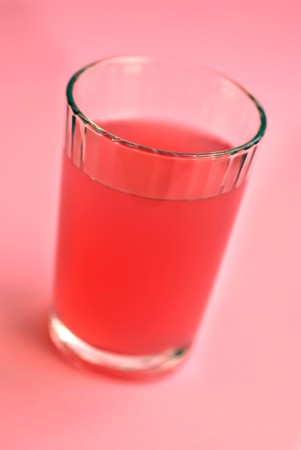 Glass of fresh raspberry lemonade on a pink backgroundの写真素材