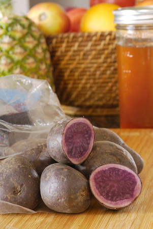 Fresh blue potatoes in plastic sack in kitchenの写真素材