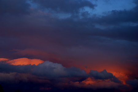 Storm clouds at sunset in purple, orange, pink, blue