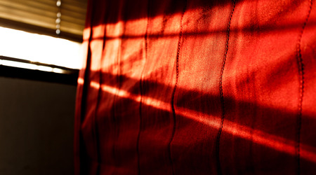 sunshine from window to red fabric photoの写真素材