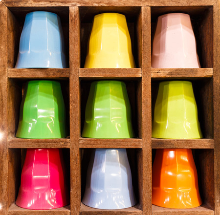 colors plastic cup in wooden tube table photo