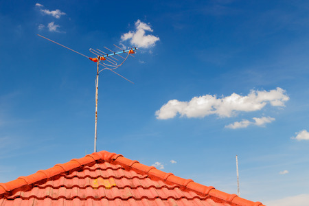 old TV antenna on roof photo,blue sky backgroundの写真素材