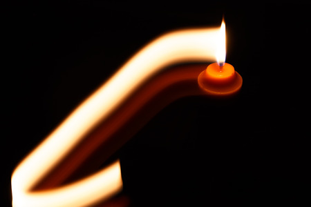 abstract yellow candle isolation on black background photoの写真素材