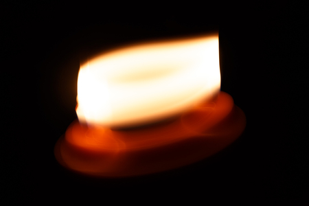 abstract yellow candle isolation on black background photoの写真素材
