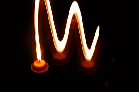 abstract yellow candle isolation on black background photoの写真素材