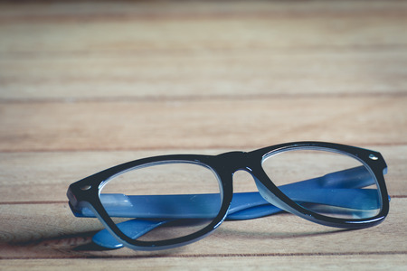 close up glasses on wooden background, vintage toneの写真素材