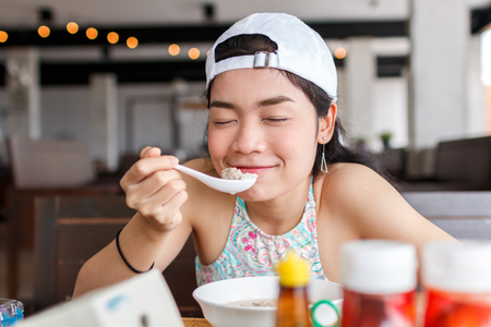 beauty asian woman with white hat eatting foodの写真素材