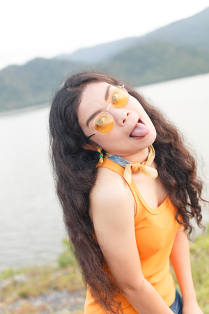 portrait beauty young asian woman long black curly hair in yellow vestの写真素材