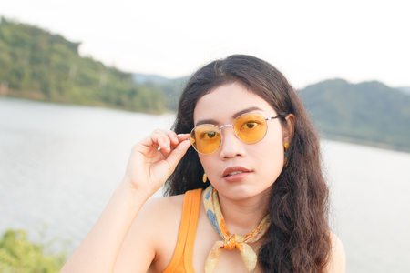 portrait beauty young asian woman long black curly hair in yellow vestの写真素材
