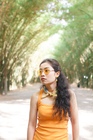 portrait beauty young asian woman long black curly hair in yellow vestの写真素材