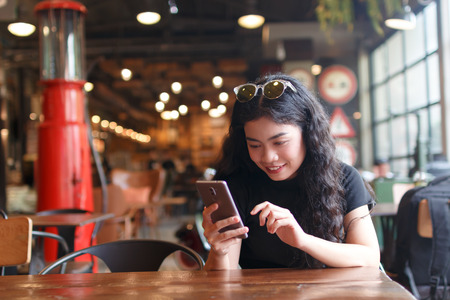 A young beauty asian woman sitting at chair and use smartphone, traveling at Bangkok Thailand