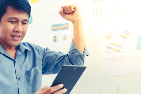 asian business man wear blue shirt and hold smart phone with white board on backgroundの写真素材