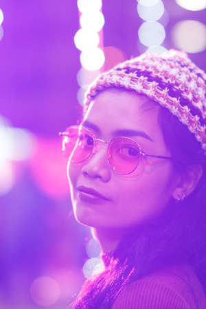 beauty asian woman with glasses and color light bokeh blur on backgroundの写真素材