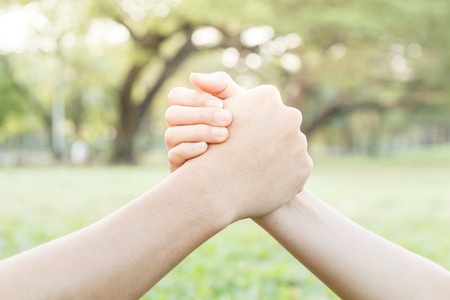 close up holding hand of asian man and woman on blur park background