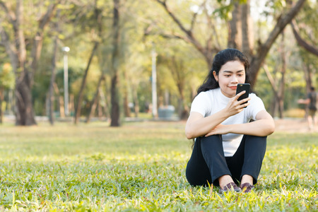 close up beauty asian woman in white shirt and use smartphone on blur backgroundの写真素材