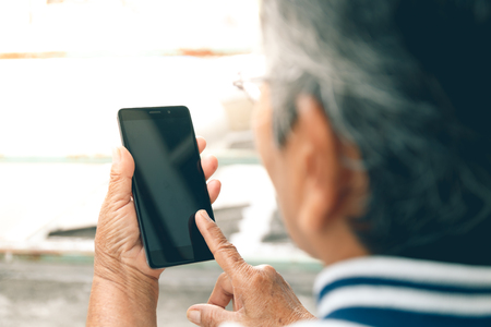 close up hand of old asian woman hold smartphoneの写真素材
