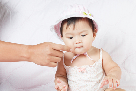 close up asian adorable baby, new born children toddler on soft textile bedの写真素材