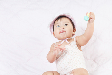 close up asian adorable baby, new born children toddler on soft textile bedの写真素材