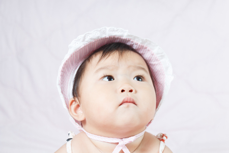 close up asian adorable baby, new born children toddler on soft textile bedの写真素材