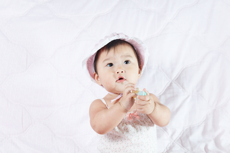 close up asian adorable baby, new born children toddler on soft textile bedの写真素材