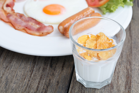 close up breakfast set with bacon fried egg and ham on wooden table backgroundの写真素材