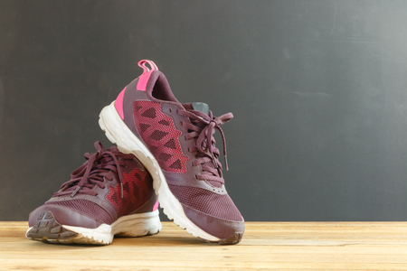 close up woman running shoes on wooden table and black backgroundの写真素材