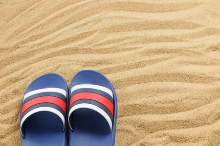 close up blue sandals on sand of beach, summer conceptの写真素材