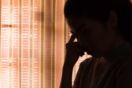 depression asian woman is sad and stress in bedroom, close up at faceの写真素材