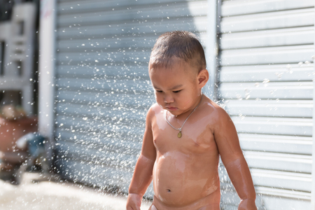 close up kid shower and play with water on outdoorの写真素材