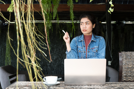 business asian woman with laptop and white cup of coffee on outdoor, relaxation conceptの写真素材