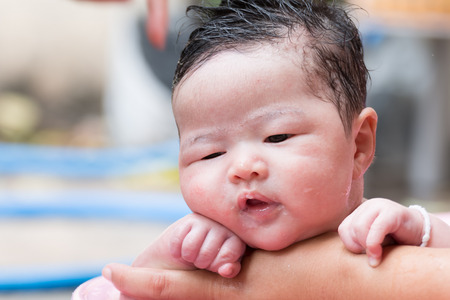 close up face of asian newborn take a bath with her motherの写真素材
