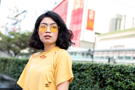 beauty asian woman with yellow wear and glasses in cityの写真素材