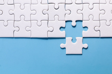 close up white color a part of jigsaw on blue color background and one part out of group with conceptの写真素材