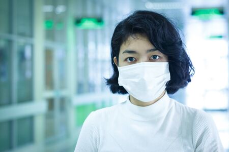 asian woman protection virus with mask on blur hospital backgroundの写真素材