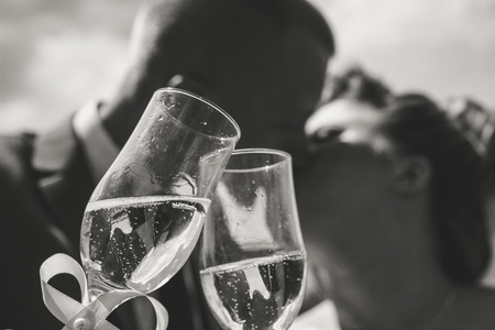 Wedding details. newlyweds, kiss, holding a glass of champagne, celebrating their weddingの写真素材