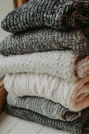 knitted sweaters on a soft peach carpet close-up, place for text - Imageの写真素材