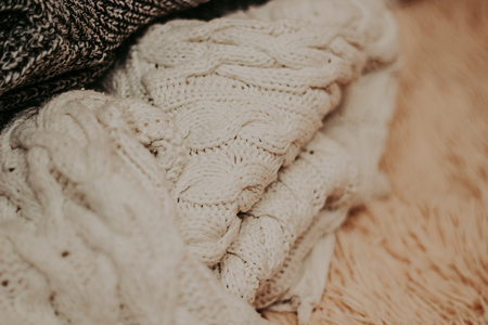 Background with warm sweaters. Pile of knitted clothes, warm background, knitwear, space for text, autumn winter concept. Copy space. - Imageの写真素材
