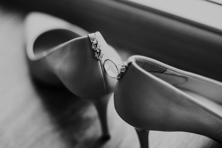 Wedding rings between white wedding shoes for women with wedding rings on a white background. - Imageの写真素材