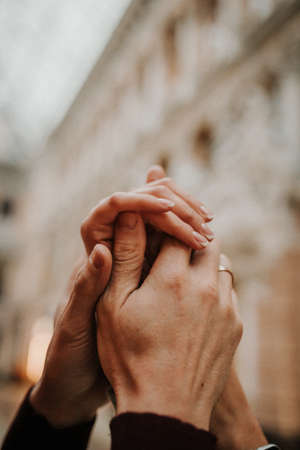 A gentle touch of the hands of a man and a woman close-up. A loving couple holding hands.の写真素材